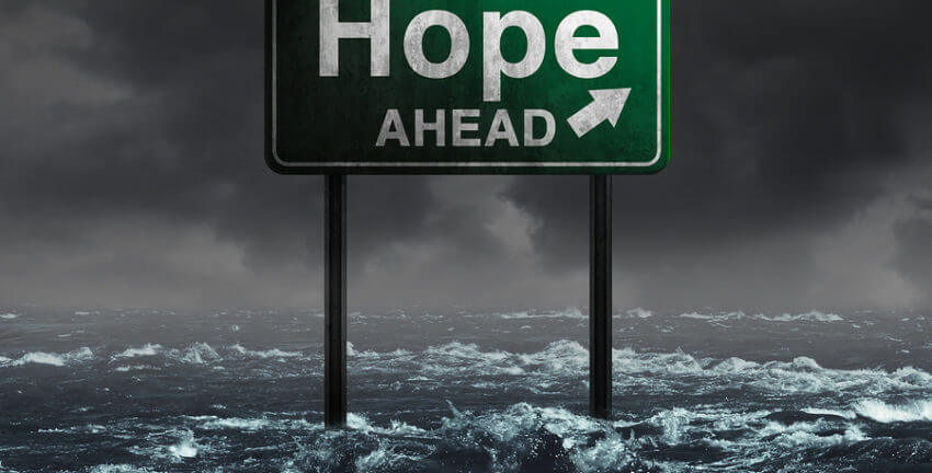 The sign that says HOPE AHEAD in the middle of a stormy ocean