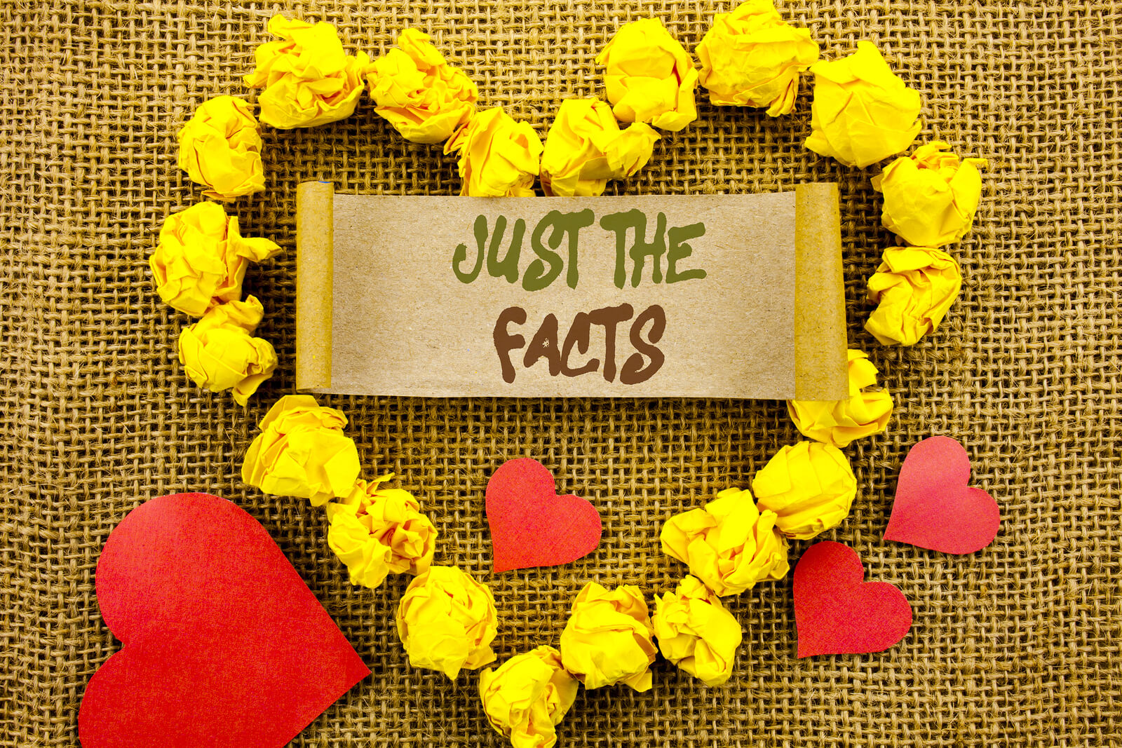 red hearts with a bigger yellow crumbled up paper shaped in a heart with the words just the facts in the center