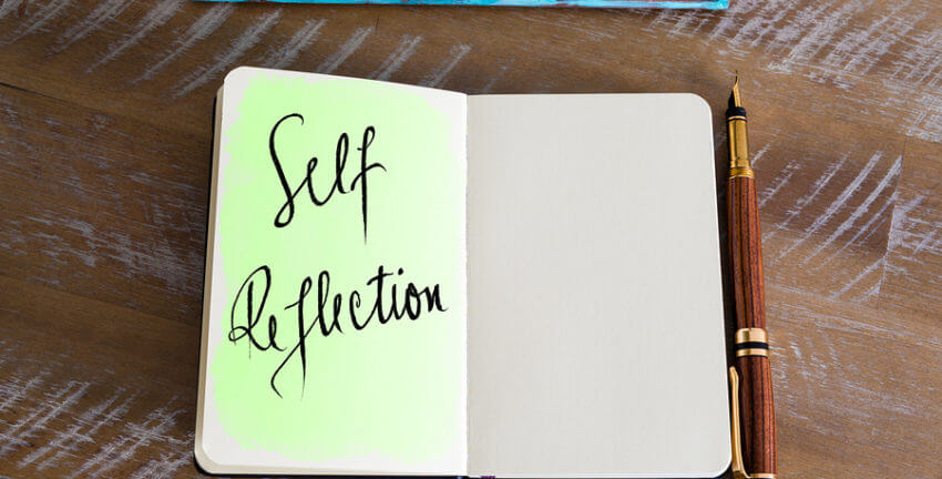 A notebook with one side written "self reflection"