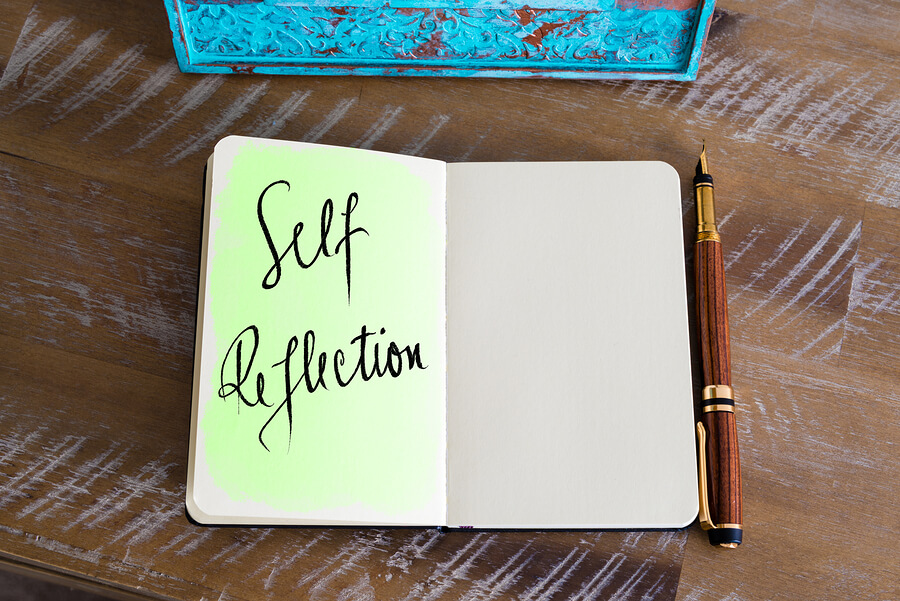 A notebook with one side written "self reflection"