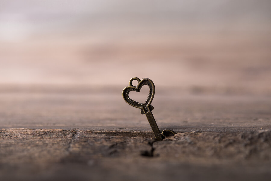 A key with a heart digging into the ground